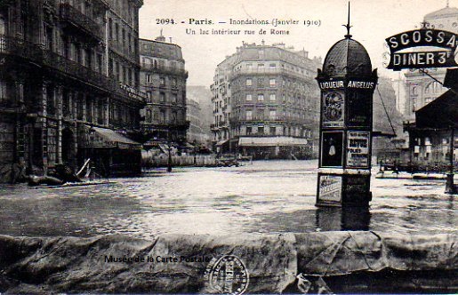 Carte postale ancienne représentant un kiosque à journaux de la rue de Rome à Paris, pendant les inondations de 1910.