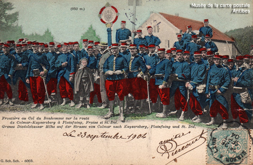Carte postale ancienne représentant un poteau à la frontière franco-allemande avec des soldats.