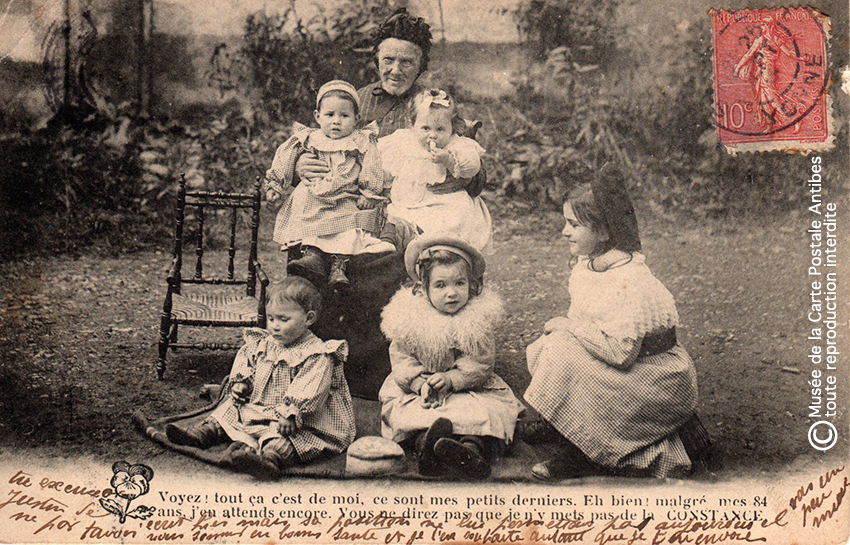 Carte postale ancienne représentant une grand-mère et ses petits-enfants.