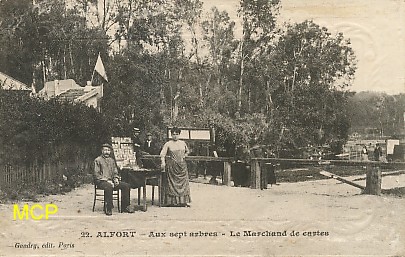 Carte postale représentant des marchands ambulants vendant des cartes postales. Cette carte est exposée au musée de la carte postale, à Antibes.