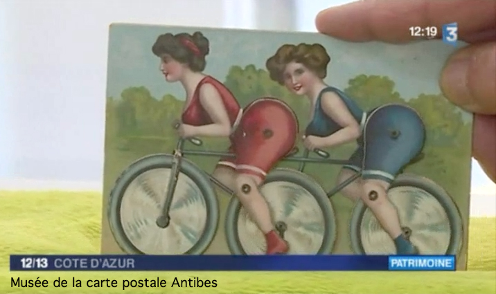 Carte postale animée ancienne représentant deux femmes sur un tandem, issue de l'exposition temporaire du musée de la carte postale consacrée au vélo et bicyclette.
